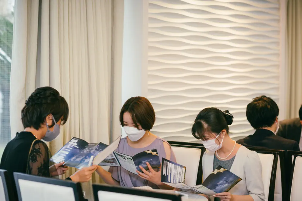 結婚式当日、ペーパーアイテムを見ているゲスト